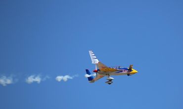 Avião de pequeno porte sobrevoando um aeroclube.