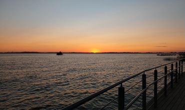 Orla com paisagem do pôr do sol.