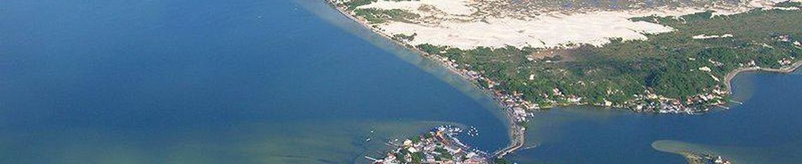 Vista aérea da Lagoa da Conceição com as dunas de Florianópolis - SC ao fundo.