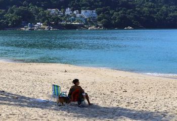 Turista na areia da Praia Martim de Sá em Caraguatatuba - SP.