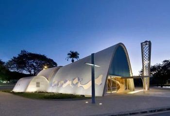 Vista noturna da Capela de São Francisco de Assis iluminada. 